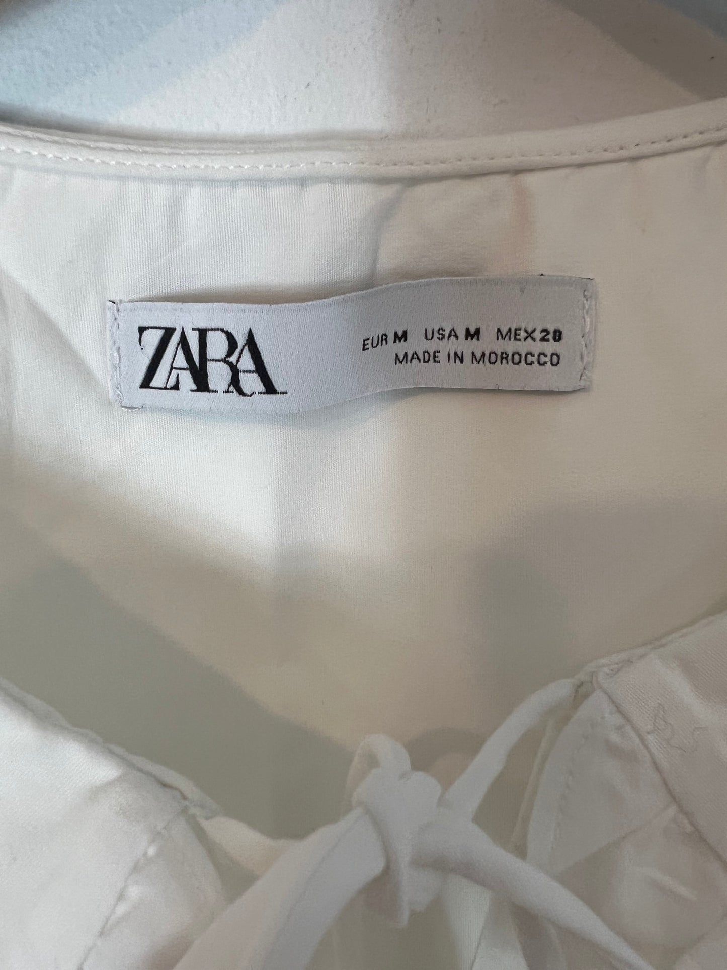 ZARA. Blusa blanca sin mangas volante. T M