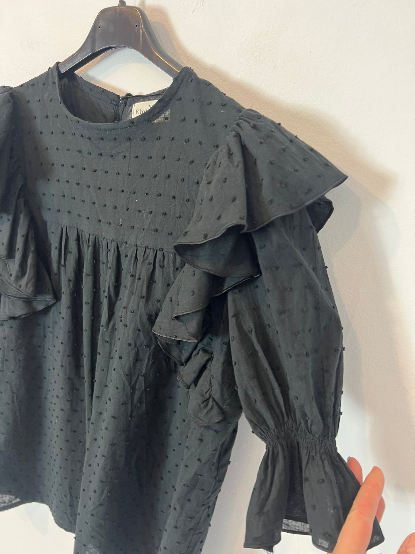 ELEFANTINE. Blusa negra plumeti detalle volante. T M