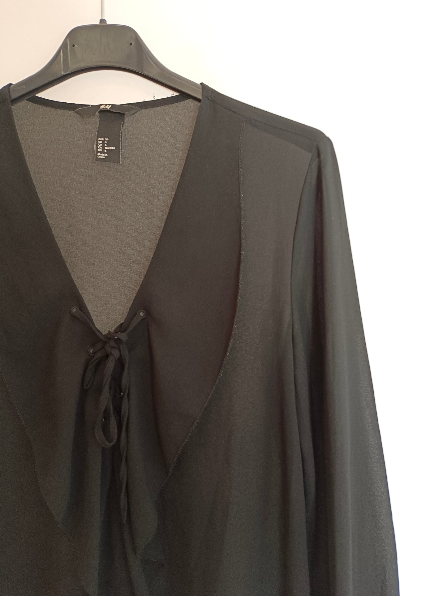 H&M. Blusa negra volante T.36