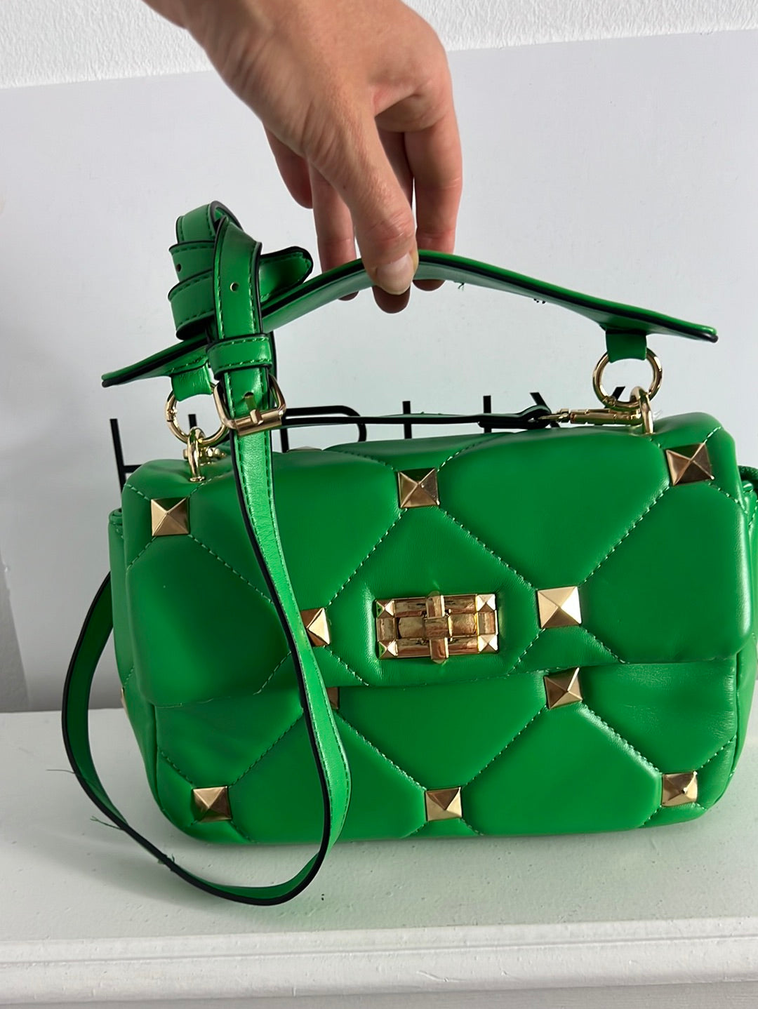 OTRAS. Bolso verde tachuelas doradas