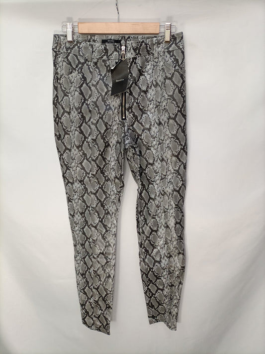 BERSHKA. Pantalones serpiente T. L